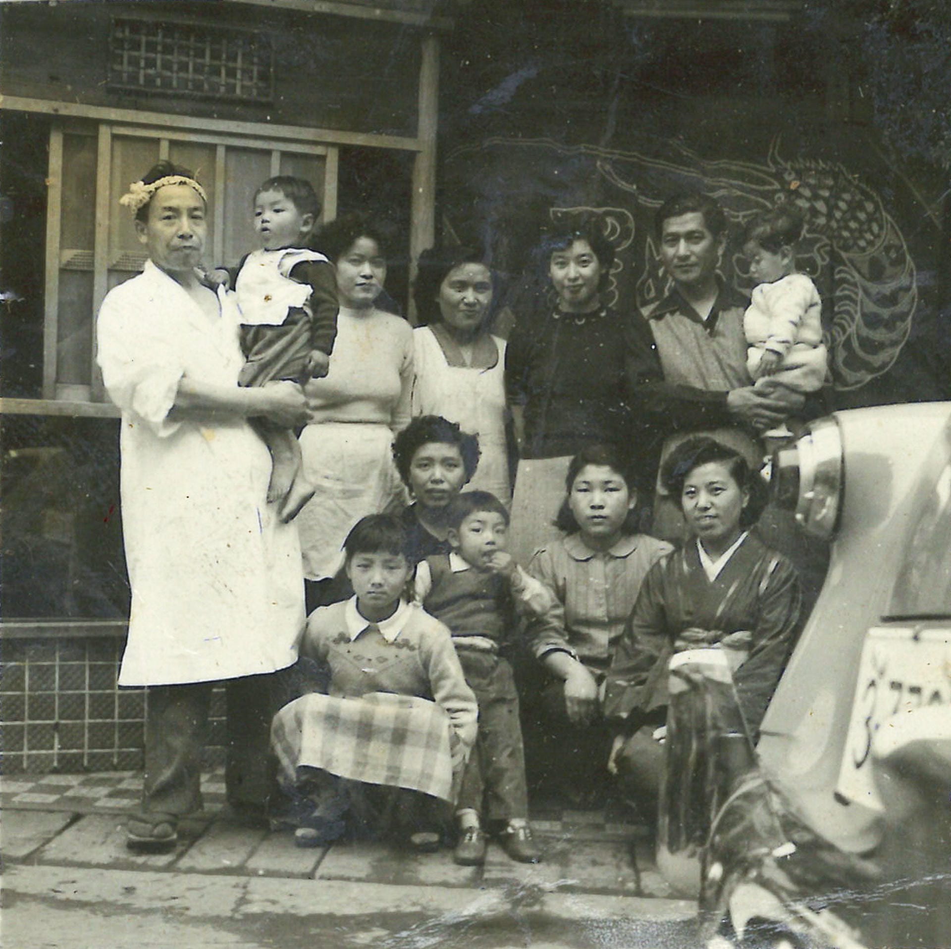 店主・寅吉（左端）と佐野周二さん（後列右端）は家族ぐるみの付き合い。店の前での記念写真