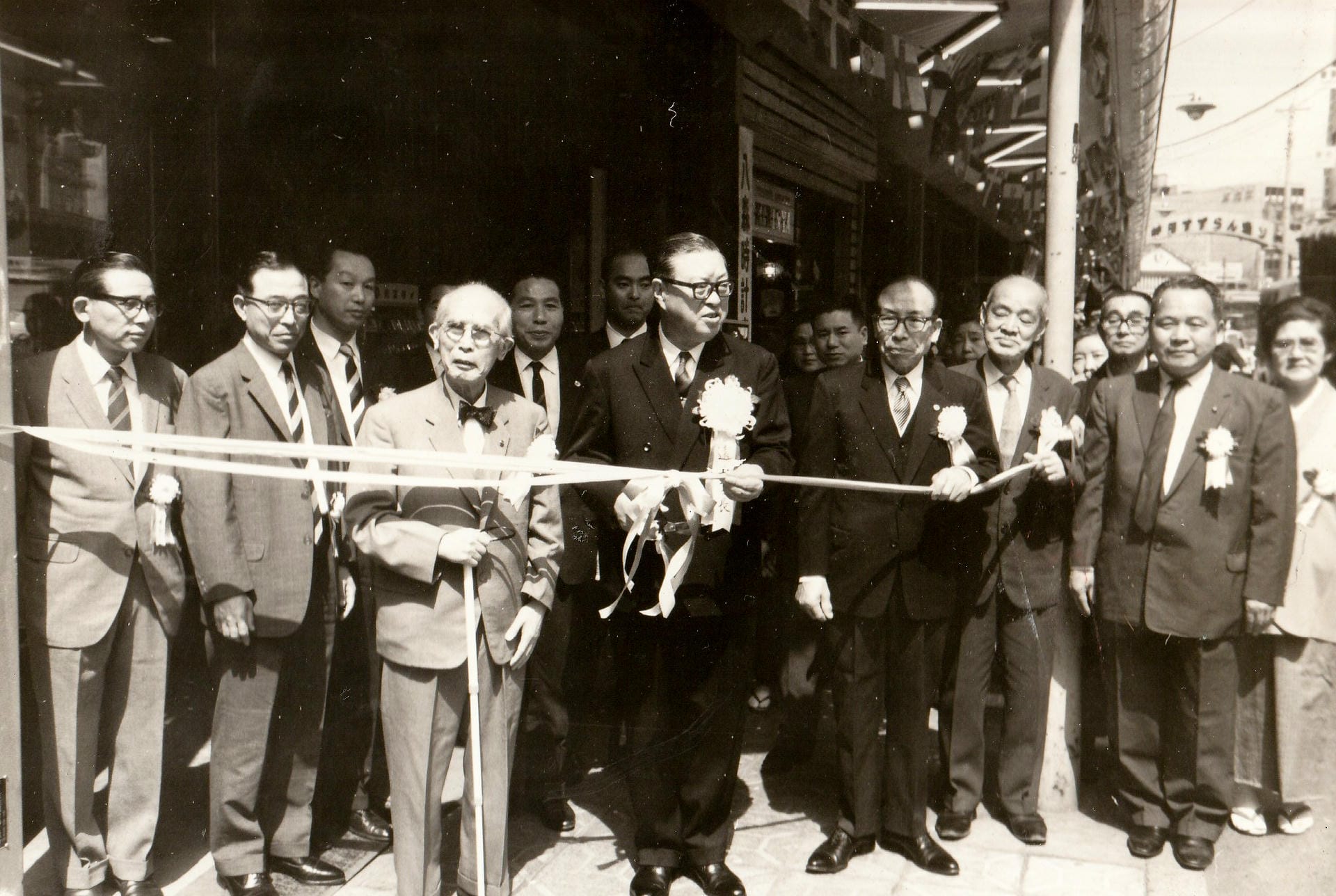 すずらん通りのアーケードが完成し、テープカットを行う、遠山千代田区長（中央）と寅吉（右隣）